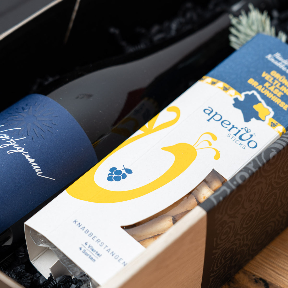 Witzigmanns Veltliner mit Knabberstangen – geöffnetes Geschenkpaket