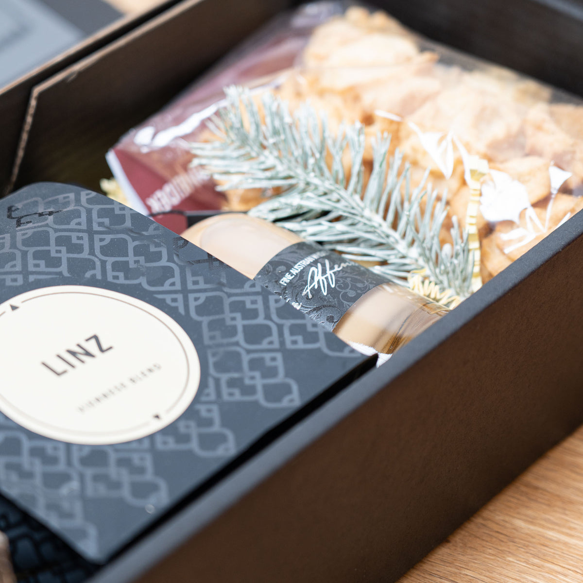 Kaffee, Whisky Cream & Busserl – geöffnetes Geschenkpaket